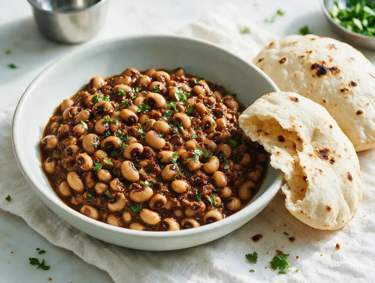 Creamy black-eyed pea lobia masala in a bowl with puffed pale jowar bhakri