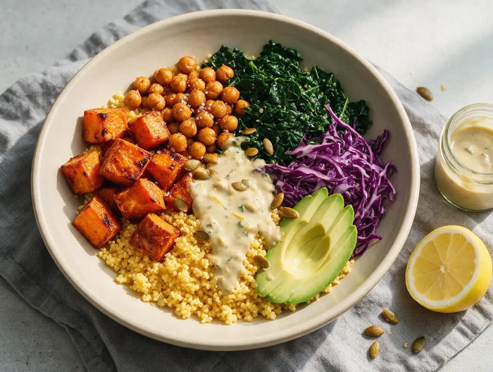 Composed millet bowl with roast sweet potato, chickpeas, kale, avocado and tahini drizzle