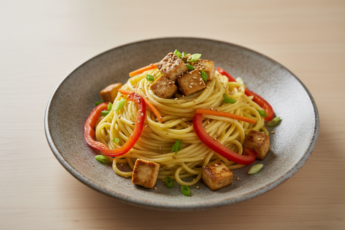 Pale gold sprouted foxtail millet noodles with tofu and sautéed vegetables